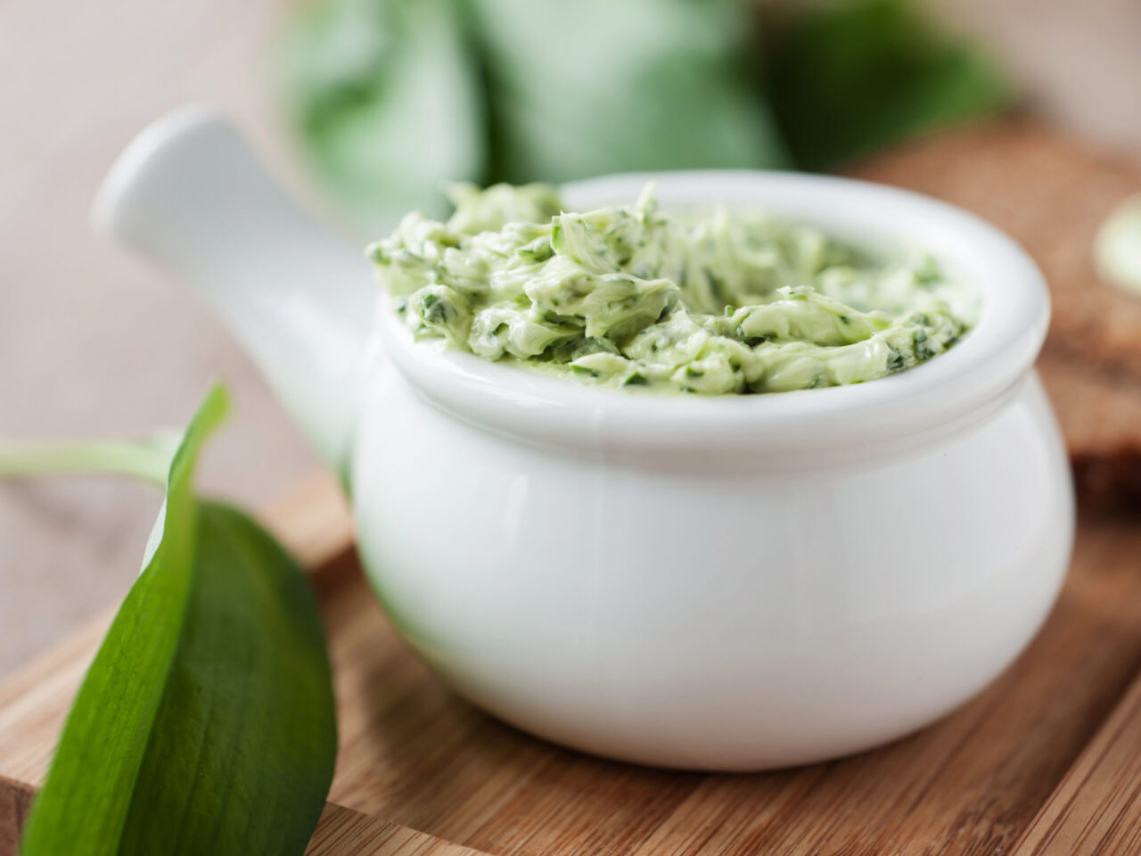 Bärlauchbutter in einem weißen Porzellantöpfchen